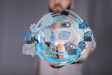A man interacts with a digital interface showing various app icons, representing modern technology...