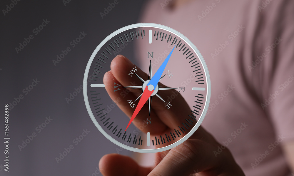 Aufkleber Close-up of a hand interacting with a digital compass, showing navigation and direction.
