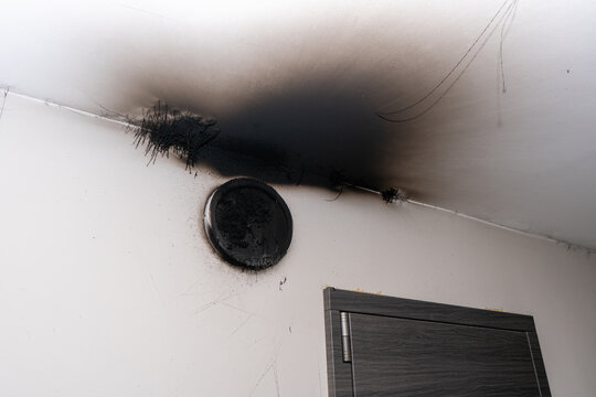 Burnt out LED lamp. A lampshade lamp on the wall after a fire. Spontaneous combustion and fire in a residential building. Indoor apartment