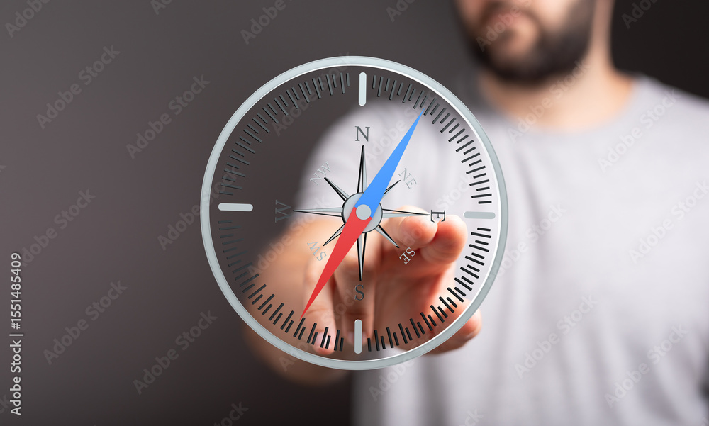 Aufkleber Close-up of a man interacting with a digital compass, illustrating navigation and direction.