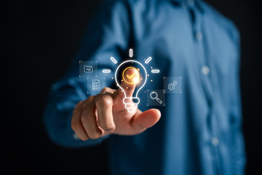 Quick tip of Businessman touching glowing light bulb with checklist, symbolizing innovative idea, smart solution, productivity improvement, and successful strategy in digital age.
