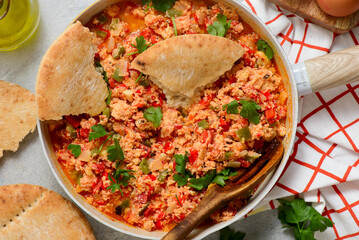 Turkish menemen fried eggs in a frying pan with pita bread. selective focus. hugge style