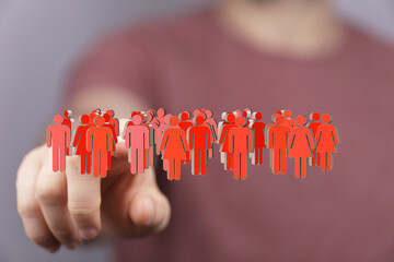 Hand pointing at diverse group of people icons.  Concept for teamwork, community, and inclusion.