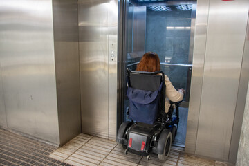 Woman in wheelchair entering elevator in subway station. Concept of inclusion, adapted public
