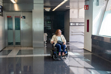 Businesswoman using wheelchair waiting in subway station. Concept of inclusion, adapted public