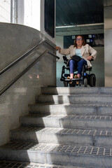 Businesswoman in wheelchair facing inaccessible subway entrance ramp. Concept of inclusion, adapted