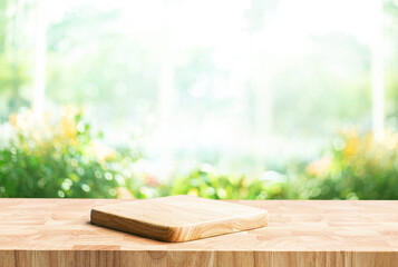 Cutting board placed on a textured wooden countertop, with soft sunlight streaming through house wall area  and blurred green landscape in the background