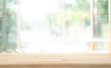 Selective focus.Empty of wood table top on soft blur of big glass window from living room background.not ai generated