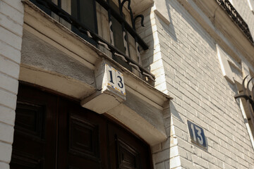 Close-up of Number Thirteen on a White Brick Building's Door