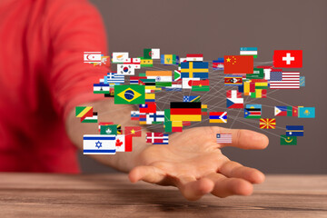 Image of a hand with interconnected world flags, symbolizing global connections and international...