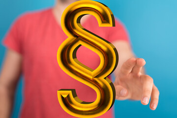 Hand reaching for a 3D golden paragraph symbol.  Legal, law, contract, agreement concept.