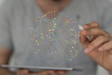 Abstract image of a person using a stylus to interact with a colorful network visualization on a...