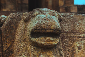 Close-up of an ancient lion sculpture carved in stone at a heritage temple site in Badami,...