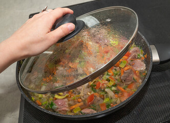 Cooking a Delightfully Colorful Dish Featuring Vegetables and Meat in a Pan for Your Family