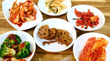 Traditional Korean banchan feast with multiple fermented vegetable side dishes including kimchi lotus root and pickled vegetables spread