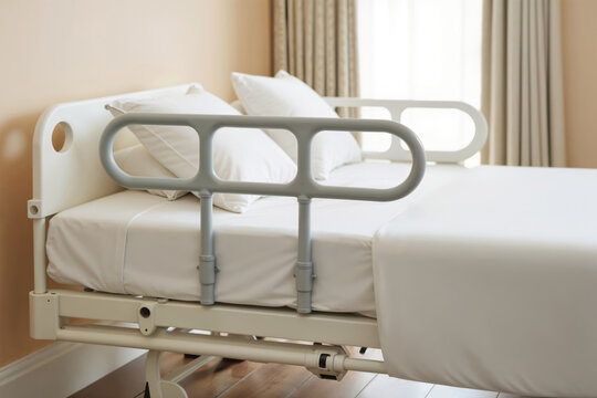 Hospital Bed Safety Rail. A close-up view of an adjustable side rail on a clean hospital bed, emphasizing patient safety and support.