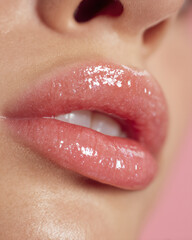 Delicate soft pink lips glisten with clear lip gloss, showcasing fresh and youthful appearance. close up highlights smooth texture and shine, evoking sense of beauty and allure