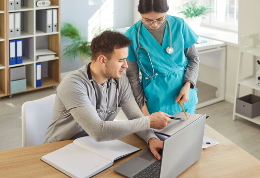 Doctor and nurse working together with documents in clinic office, conducting research, focusing on healthcare teamwork with a sense of collaboration and medical precision and care.