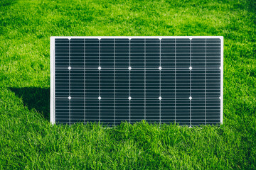 Solar panel generating renewable energy on green grass in a summer sunny day.