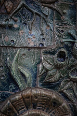 Intricate stone carving showcasing nature motifs at an ancient site in a vibrant natural setting