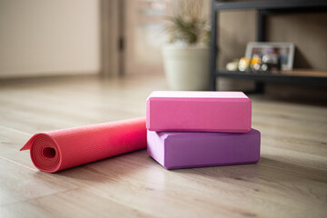 Colorful yoga blocks and mat arranged in a cozy indoor space perfect for practice