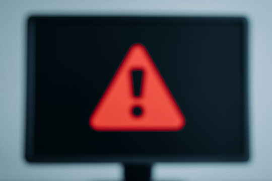 Blurred computer screen showing virus warning popup, digital security alert signaling malware threat, ransomware or phishing attack
