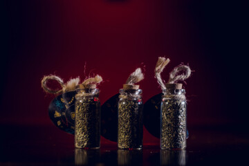 bottles with spices stand in the mirror surface on a red background