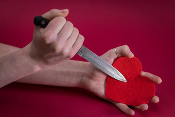 Valentines Day. Love heart. Breakheart. Female hand and pierces it heart knife