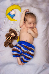 sleeping newborn dressed a pants with toon bear and moon