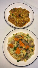 Homemade Indonesian Stir-Fried Vegetables with Meatballs and Savory Omelette on White Plates