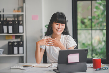 Asian businesswoman making video call meeting communicating with client via online conference on tablet computer working from home office