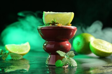 Hookah bowl with limes, mint and smoke on black table, closeup