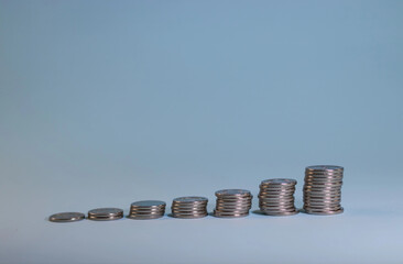 stacks of coins exhibited staircase on a blue background.