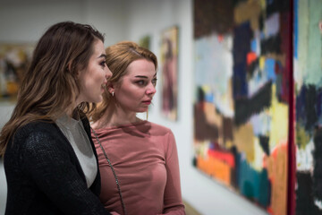 two girls discuss paintings in Gallery of modern art