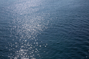 Vue aérienne de la surface de la mer de couleur bleu avec scintillements du soleil et vagues douces