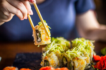Girl eats Japanese vegetarian rolls
