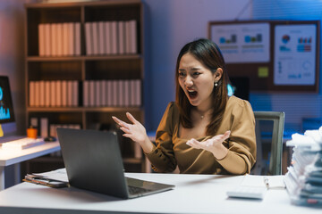Young professional woman working late showing frustration during a video conference on her laptop