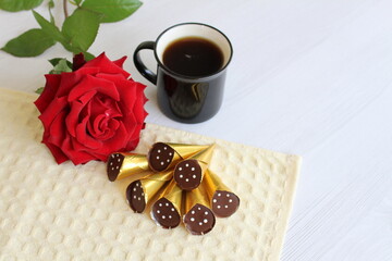 favorite chocolates, with a cup of coffee and a fragrant rose, a pleasant start to the day