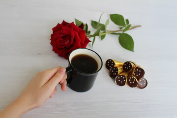 a cup of coffee with interesting chocolates and a cute red rose is a nice start to the day