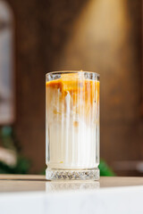 Iced latte in a clear glass with visible coffee and milk layers