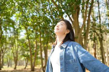 両手を広げて春の自然を全身で感じている女性の開放感あるシーン