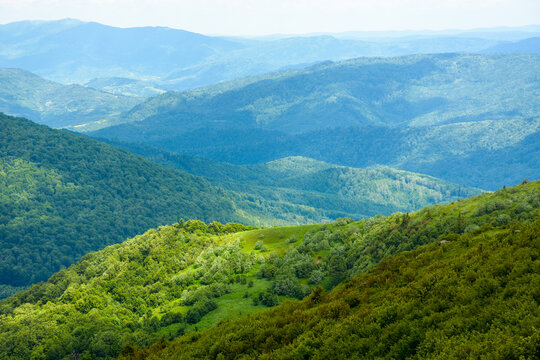 wonderful mountain landscape for travel with green hill in summer. nature scenery with scenic view in to the distant valley of carpathians in dappled light. hiking through transcarpathia highland