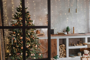 Home New Year's interior. Christmas tree with gifts, decorated with garlands in the kitchen. Cozy...