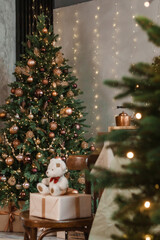 Home New Year's interior. Christmas tree with gifts, decorated with garlands in the kitchen. Cozy atmosphere of a home holiday, loft design of the room, Scandinavian style.