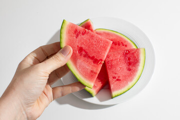 Hand holding vibrant watermelon slices, sunlit summer essence, hydrating refreshment for...