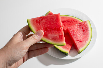 Hand holding vibrant watermelon slices, refreshing summer solstice feast, juicy delight, perfect...