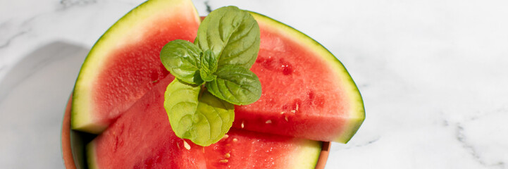 Juicy watermelon slices, adorned with dewy basil leaves, evoke summer picnics and Watermelon Day...