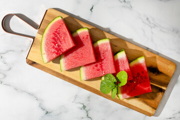 Succulent watermelon slices on rustic board, evoking summer solstice celebrations, refreshing...