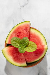 Juicy watermelon slices crowned with fresh mint evoke summer solstice picnics and National...