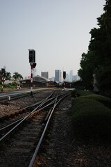 Railway junction with signal light and city skyline in the background